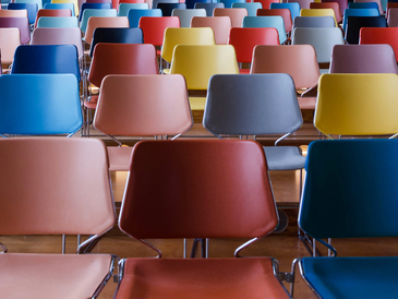 Bunte Stuhlreihen in einem Seminarraum