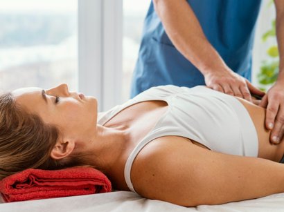 Front view of male osteopathic therapist checking female patient s abdomen